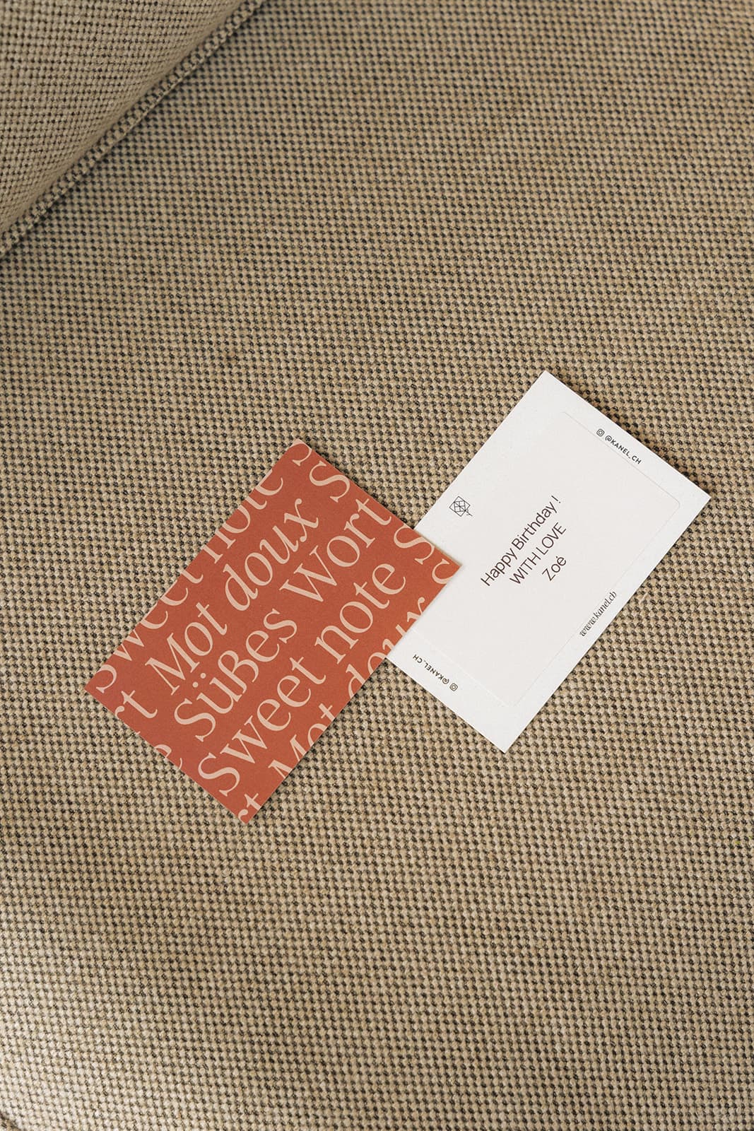 Red and white KANEL message cards on fabric