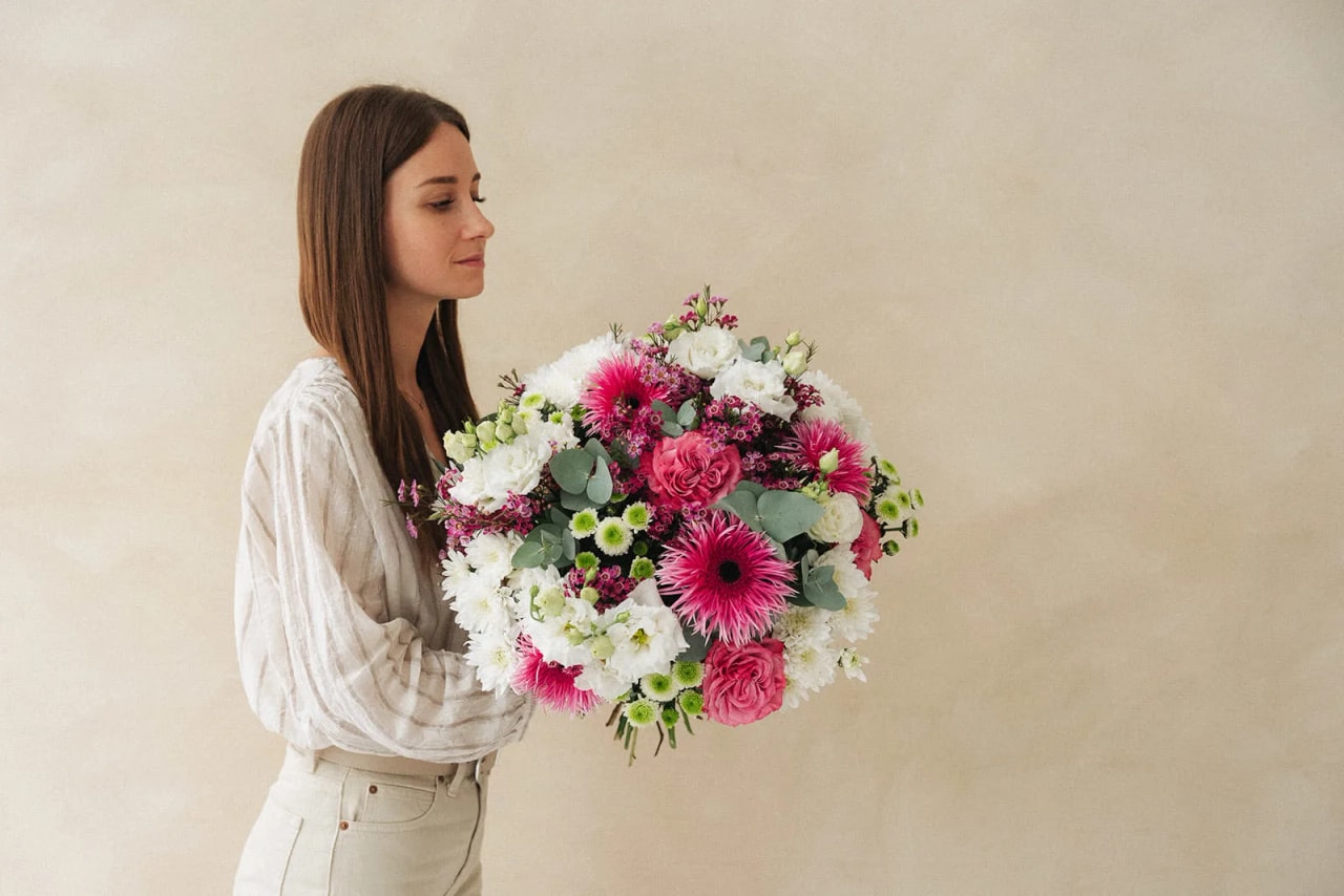 Eine Frau mit einem rosa-weissen Blumenstrauss