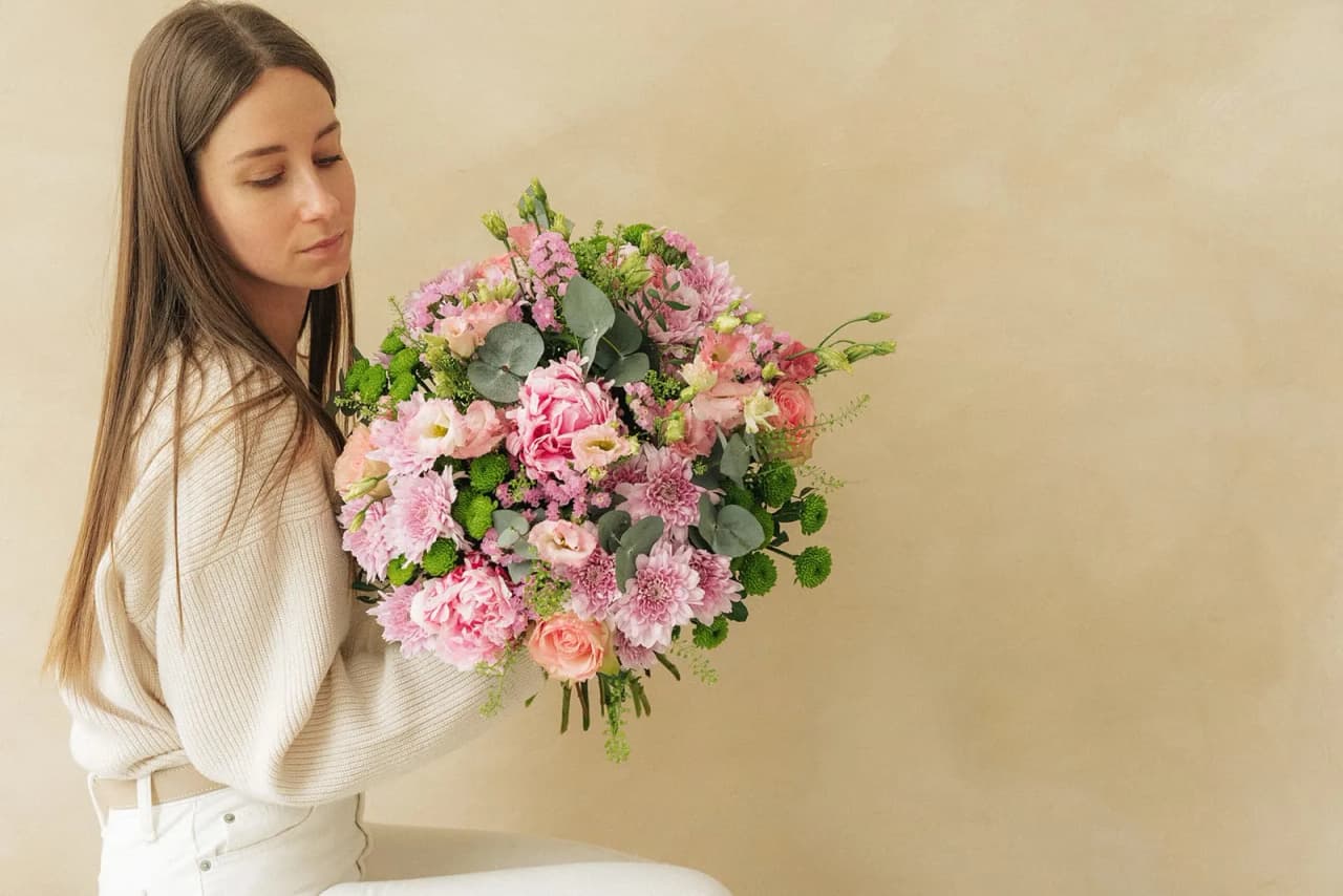 A woman holding a bouquet of pink flowers