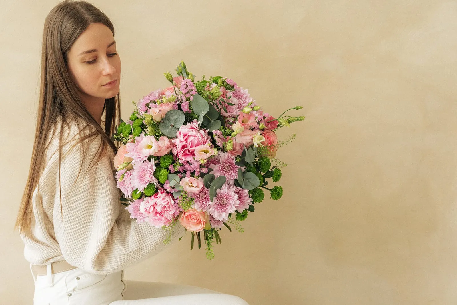 Une femme tenant un bouquet de fleurs roses