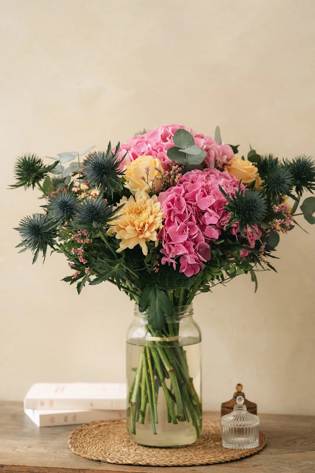 Rosa-oranger Blumenstrauss in einer Vase auf einem runden Tisch
