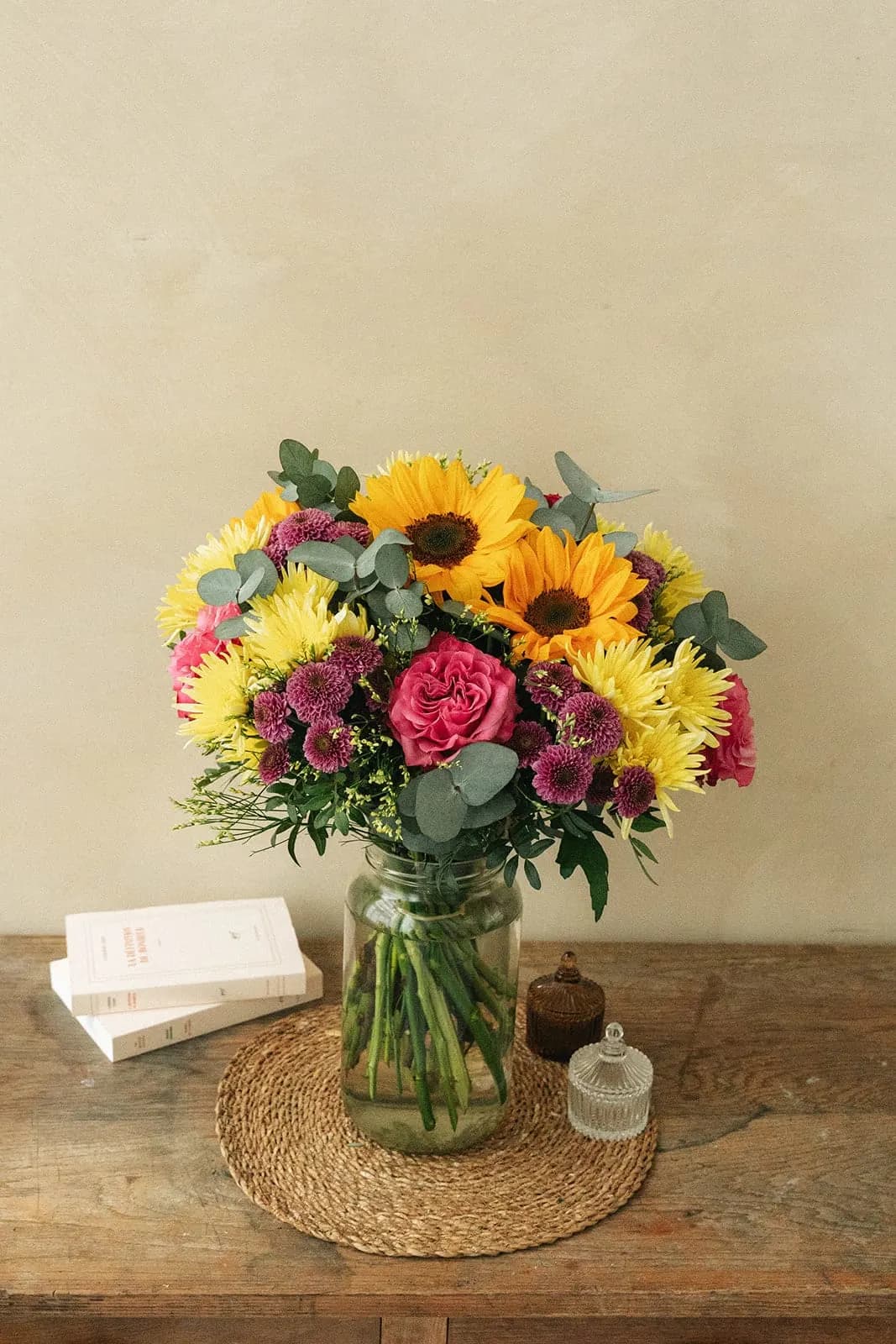 Sunflowers and pink flowers arranged in a vase